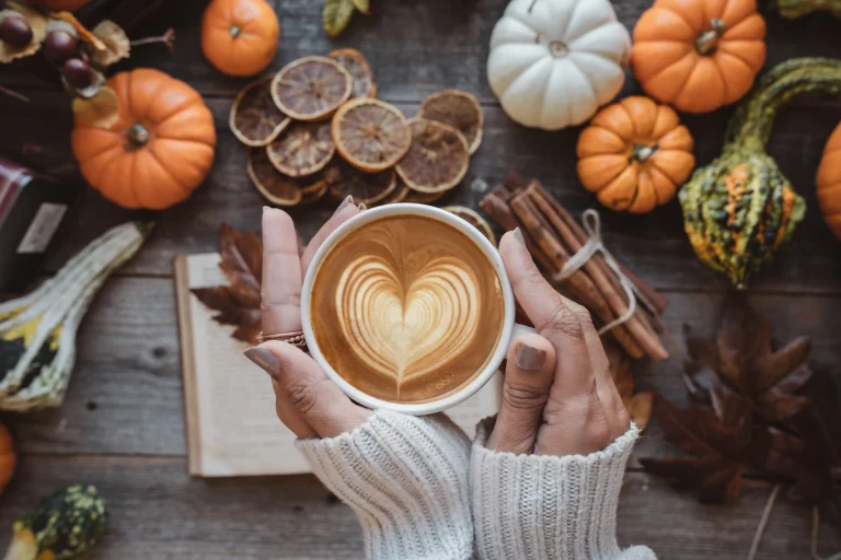 Pumpkin spice latte with pumpkins on a table, inspired by the Starbucks pumpkin menu